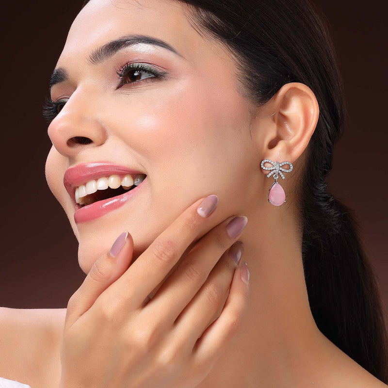 Rhodium Plated Silver Toned Bow Shaped Pink & White American Diamond Studded Drop Earrings