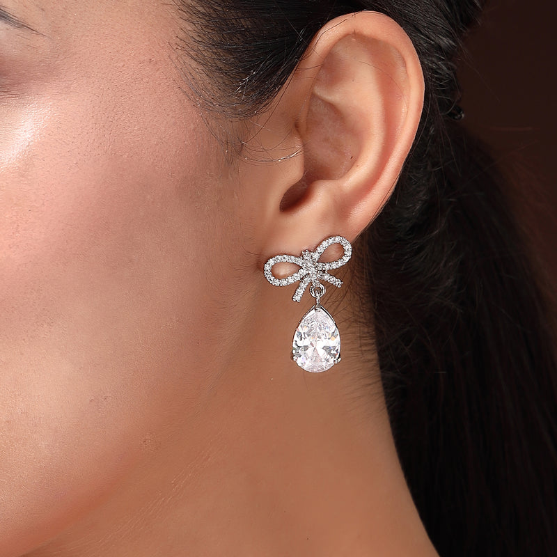 Rhodium Plated Silver Toned Bow Shaped White American Diamond Studded Drop Earrings