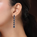 Rhodium Plated Silver Toned Teardrop Shaped Navy Blue American Diamond Studded Linear Dangler Earrings