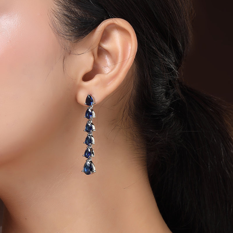 Rhodium Plated Silver Toned Teardrop Shaped Navy Blue American Diamond Studded Linear Dangler Earrings