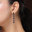Rhodium Plated Silver Toned Teardrop Shaped Purple American Diamond Studded Linear Dangler Earrings