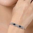 Rhodium Plated Silver Toned White Flower & Blue Teardrop American Diamond Studded Wraparound Adjustable Bracelet