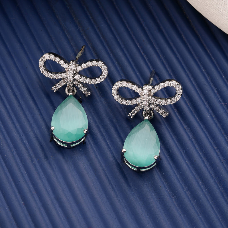 Rhodium Plated Silver Toned Bow Shaped Sea Green & White American Diamond Studded Drop Earrings