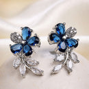 Rhodium Plated Silver Toned Floral Shaped Navy Blue & White American Diamond Studded Stud Earrings
