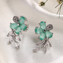 Rhodium Plated Silver Toned Floral Shaped Sea Green & White American Diamond Studded Stud Earrings